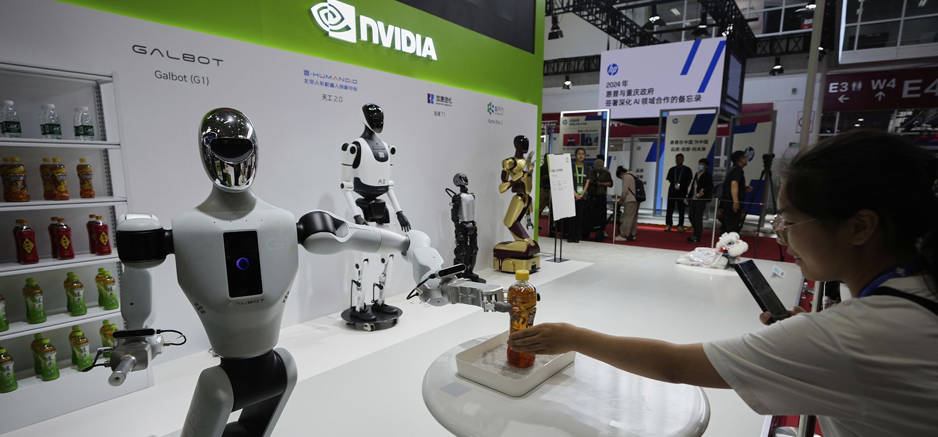Un robot en el puesto de Nvidia ofrece botellas de refrescos a los visitantes durante la 3.ª Exposición Internacional de la Cadena de Suministro de China en el Centro Internacional de Exposiciones de China, en Beijing, el miércoles 16 de julio de 2025. (Foto AP/Mahesh Kumar A.) Un robot en el puesto de Nvidia ofrece botellas de refrescos a los visitantes durante la 3.ª Exposición Internacional de la Cadena de Suministro de China en el Centro Internacional de Exposiciones de China, en Beijing, el miércoles 16 de julio de 2025. (Foto AP/Mahesh Kumar A.)