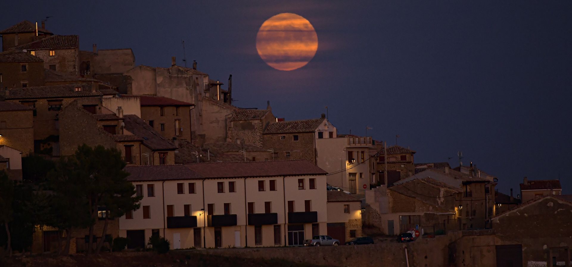 La luna conocida como luna azul sale detrás del pequeño pueblo de Ujue, al norte de España, el miércoles 30 de agosto de 2023. (Foto AP/Álvaro Barrientos)    