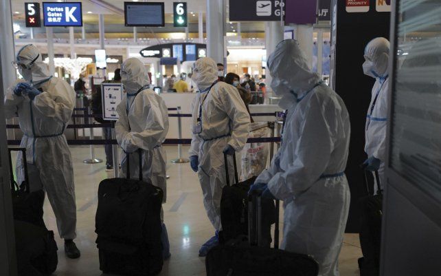 Pasajeros de Asia con equipo de protección llegan para abordar su avión en el aeropuerto Charles de Gaulle de París en Roissy, al norte de París. Francia cierra sus fronteras a las personas que llegan de fuera de la Unión Europea.