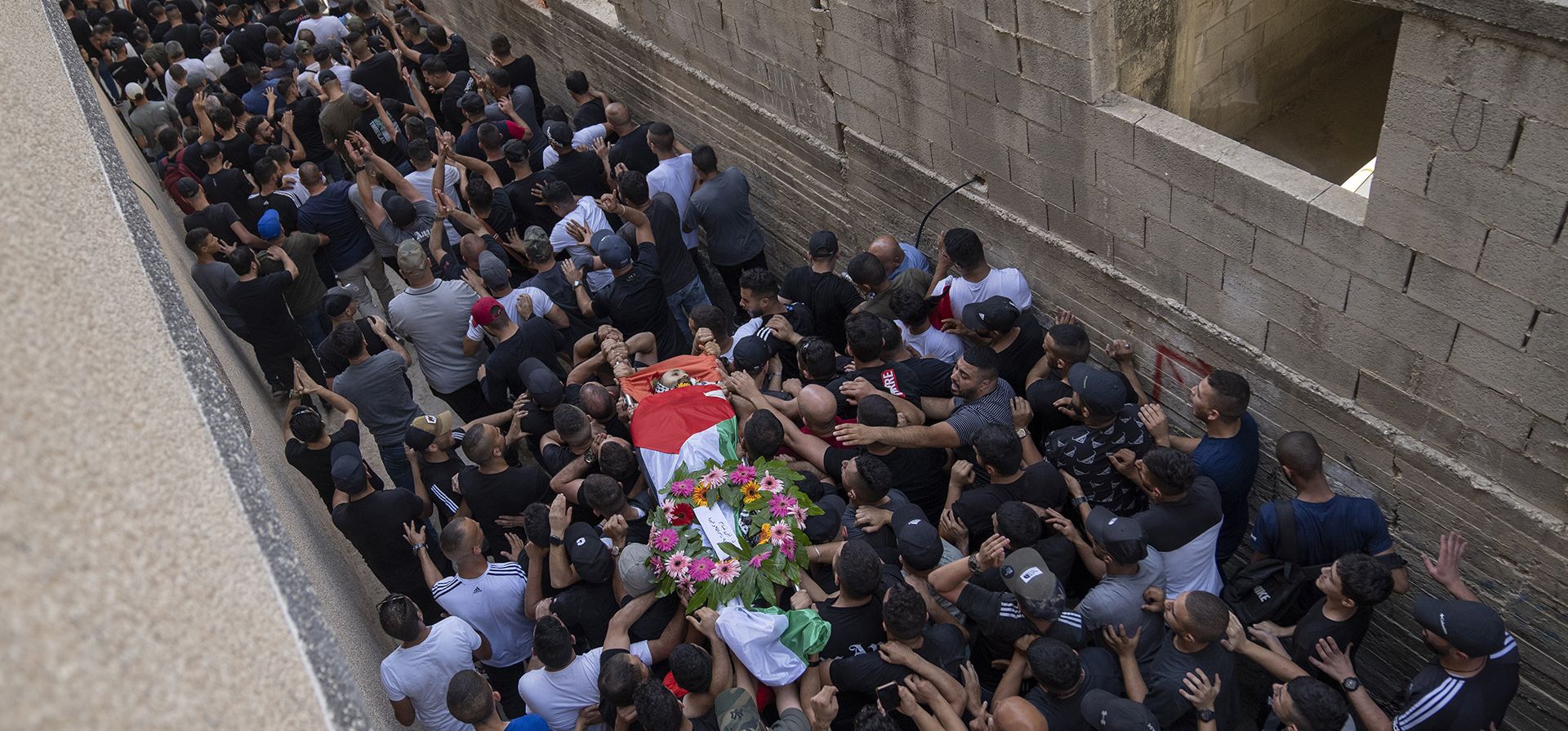 Dolientes llevan el cuerpo de Yazan Afaneh, de 26 años, quien fue asesinado a tiros por las fuerzas israelíes durante los enfrentamientos que siguieron a una redada del ejército en la ciudad de al Bireh, durante su funeral en el campo de refugiados de Qalandia, en Cisjordania, al norte de Ramallah el jueves. 1 de septiembre de 2022.