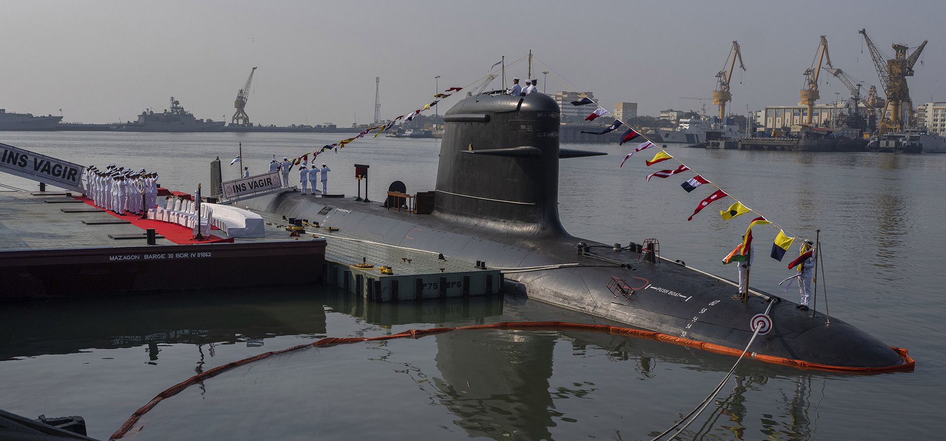 Personal naval indio y otros funcionarios posan para una fotografía durante la ceremonia de puesta en servicio del quinto submarino Vagir de la clase Kalvari en Mumbai, India, el lunes 23 de enero de 2023. (Foto AP/Rafiq Maqbool)