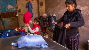 Una niña pequeña ayuda a su madre en las tareas domésticas.