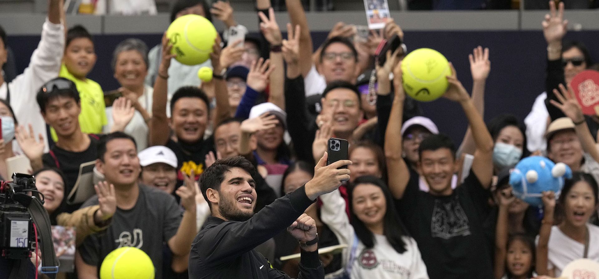 El español Carlos Alcaraz se toma una selfie con sus seguidores después de derrotar a Giovanni Mpetshi Perricard de Francia durante el torneo de tenis Abierto de China celebrado en el Centro Nacional de Tenis en Beijing, el viernes 27 de septiembre de 2024. (Foto AP/Ng Han Guan)