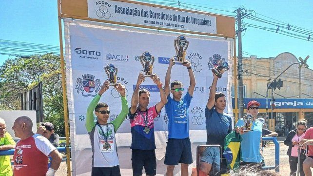 Luis Alvez (remera con estampa rosada) en el podio.