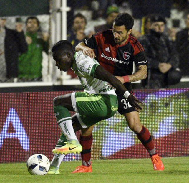 Nacho Scocco intenta robarle la pelota a Kevin Mercado.