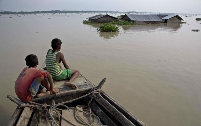 En bote. Niños navegan por la ciudad de Morigaon