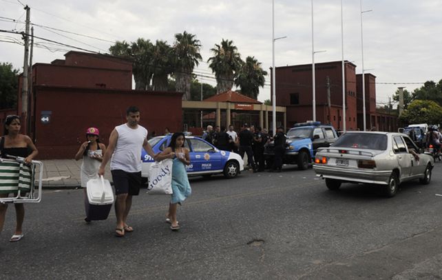 Desquicio. Una familia sale del complejo de avenida del Rosario al 500 bis frente a patrullas llegadas tras la agresión homicida contra dos jóvenes