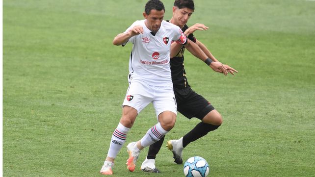 Maxi Rodríguez maneja la pelota ante uno de los volantes de Lanús.
