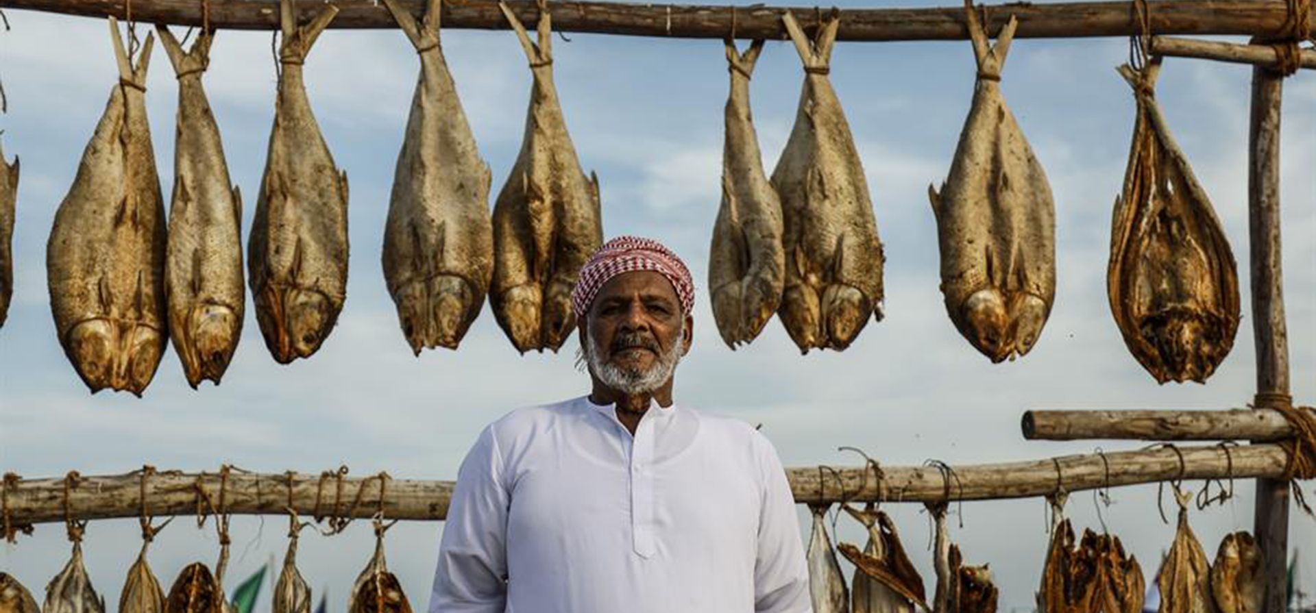 Un hombre posa junto a un puesto de venta de pescado en Katara Doha, Qatar, durante la celebración del Mundial de fútbol. EFE/Juan Ignacio Roncoroni