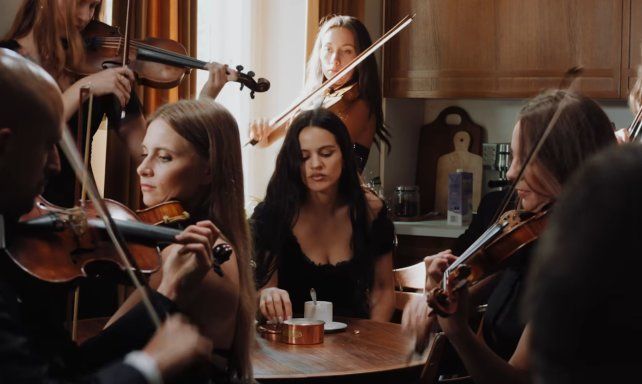 Rosalía desayuna rodeada por violinistas y un coro operístico en el videoclip de Berghain.
