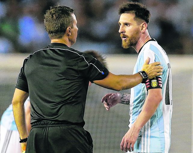 El eje de la discordia. Leo Messi dialoga con el asistente brasileño Emerson de Carvalho