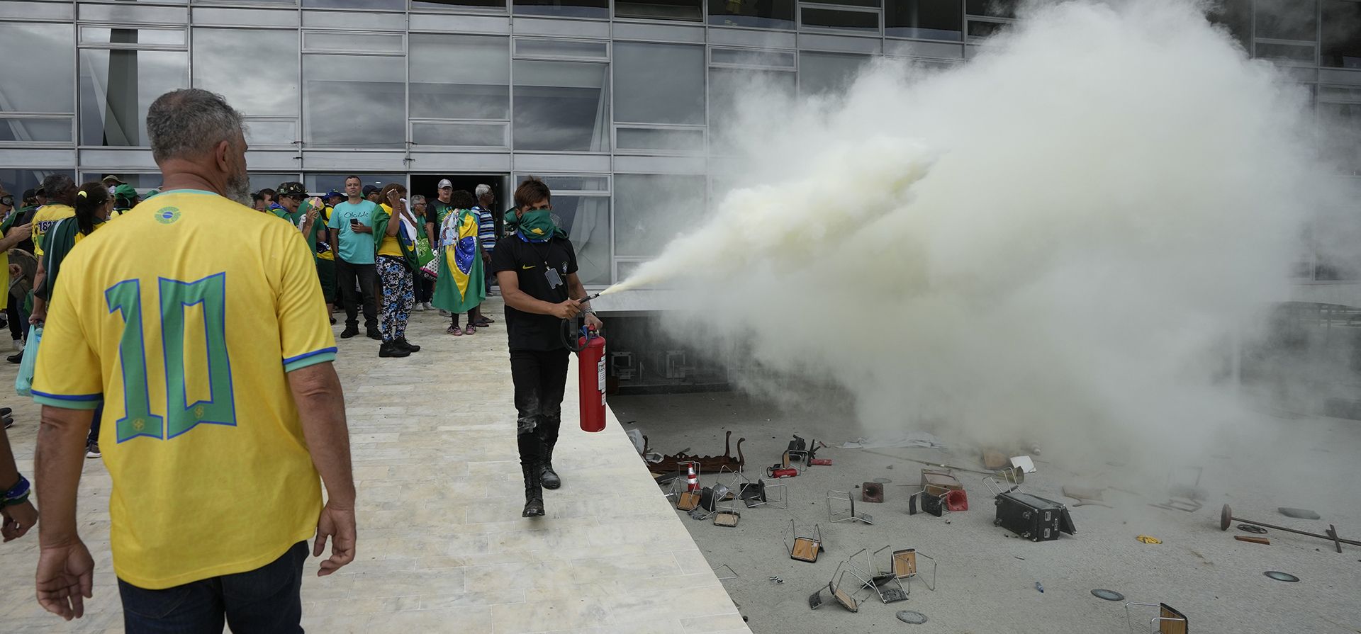 Un manifestante, partidario del expresidente de Brasil, Jair Bolsonaro, lanza un extintor de incendios después de que los manifestantes irrumpieran en el Palacio de Planalto en Brasilia, Brasil, el domingo 8 de enero de 2023. Planalto es el lugar de trabajo oficial del presidente. (Foto AP/Eraldo Peres)