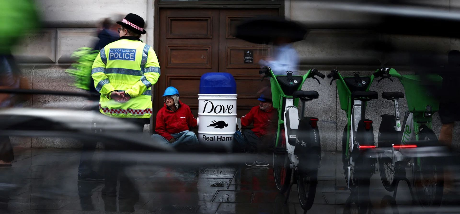 Activistas de Greenpeace bloquean la entrada a la Casa Unilever, encerrándose en barricadas hechas de un producto Dove gigante con una versión de Activistas de Greenpeace bloquean la entrada a la Casa Unilever, encerrándose en barricadas hechas de un producto Dove gigante con una versión de