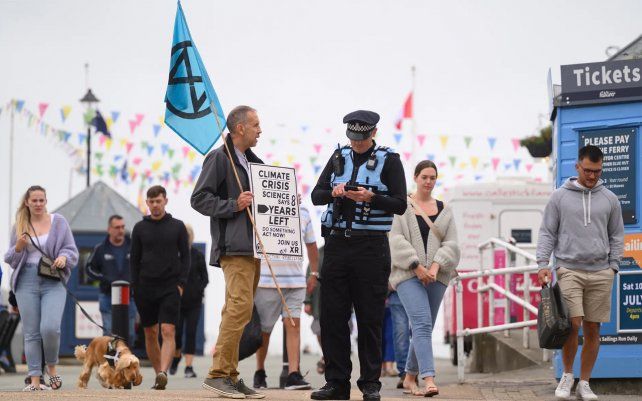 Un activista de Extinction Rebellion habla con un oficial de policía en Falmouth. Fotografía: Leon Neal / Getty Images