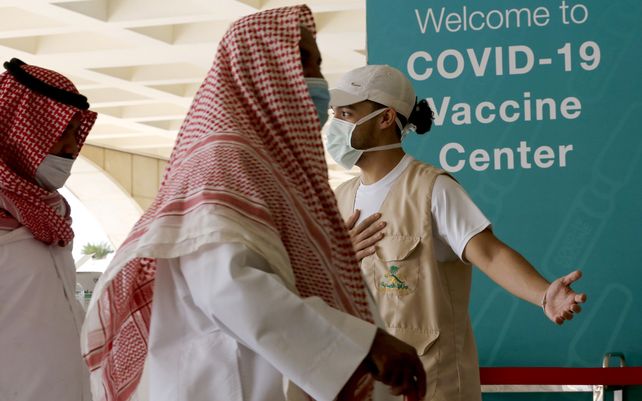 Saudíes ingresan a un centro de vacunación contra el coronavirus en el antiguo aeropuerto de Jiddah