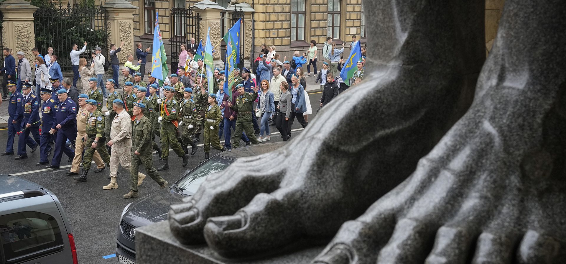 Ex paracaidistas y miembros de clubes militares juveniles marchan frente a las famosas esculturas de Atlas en el Museo Estatal del Hermitage durante la celebración del Día de los Paracaidistas en San Petersburgo, Rusia, el martes 2 de agosto de 2022.