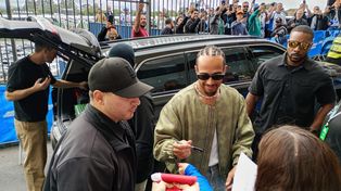Lewis Hamilton, rodeado de seguridad, se arrimó a la vallas del paddock de Interlagos para firmar autógrafos.&nbsp;
