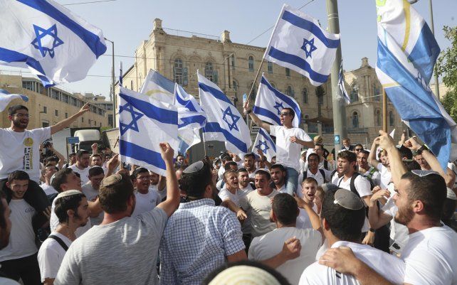 Foto de archivo: israelíes ondean banderas nacionales durante un desfile del Día de Jerusalén, en Jerusalén. La policía israelí dijo el lunes 7 de junio que bloqueó una procesión planeada por ultranacionalistas judíos a través de partes de la Ciudad Vieja de Jerusalén.