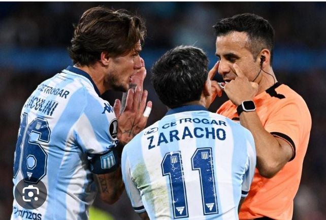 Piero Maza escucha a los jugadores de Racing. El chileno los perjudicó claramente con el tiempo adicional.
