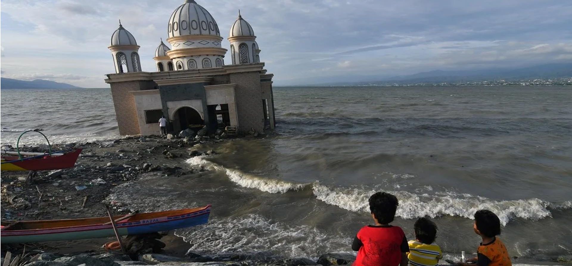 Niños se sientan cerca de una mezquita en Palu, provincia de Sulawesi Central, Indonesia, el 13 de abril de 2021. Foto: REUTERS