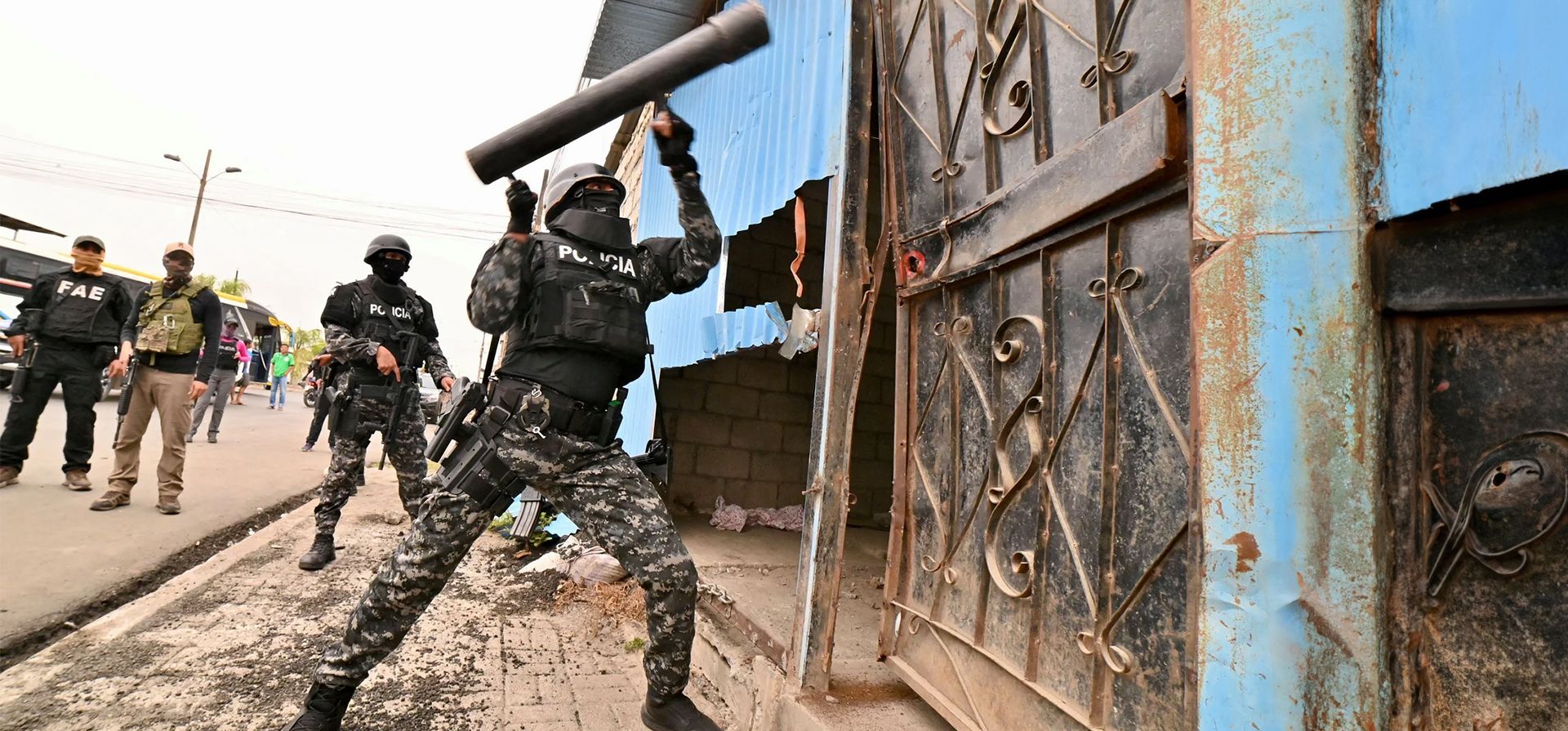 Un oficial de policía derriba una puerta para registrar una casa. Después de la operación, cuatro casas fueron demolidas y 13 presuntos pandilleros fueron arrestados, según la policía, Durán, Ecuador. Fotografía: Marcos Pin/AFP/Getty Images Un oficial de policía derriba una puerta para registrar una casa. Después de la operación, cuatro casas fueron demolidas y 13 presuntos pandilleros fueron arrestados, según la policía, Durán, Ecuador. Fotografía: Marcos Pin/AFP/Getty Images