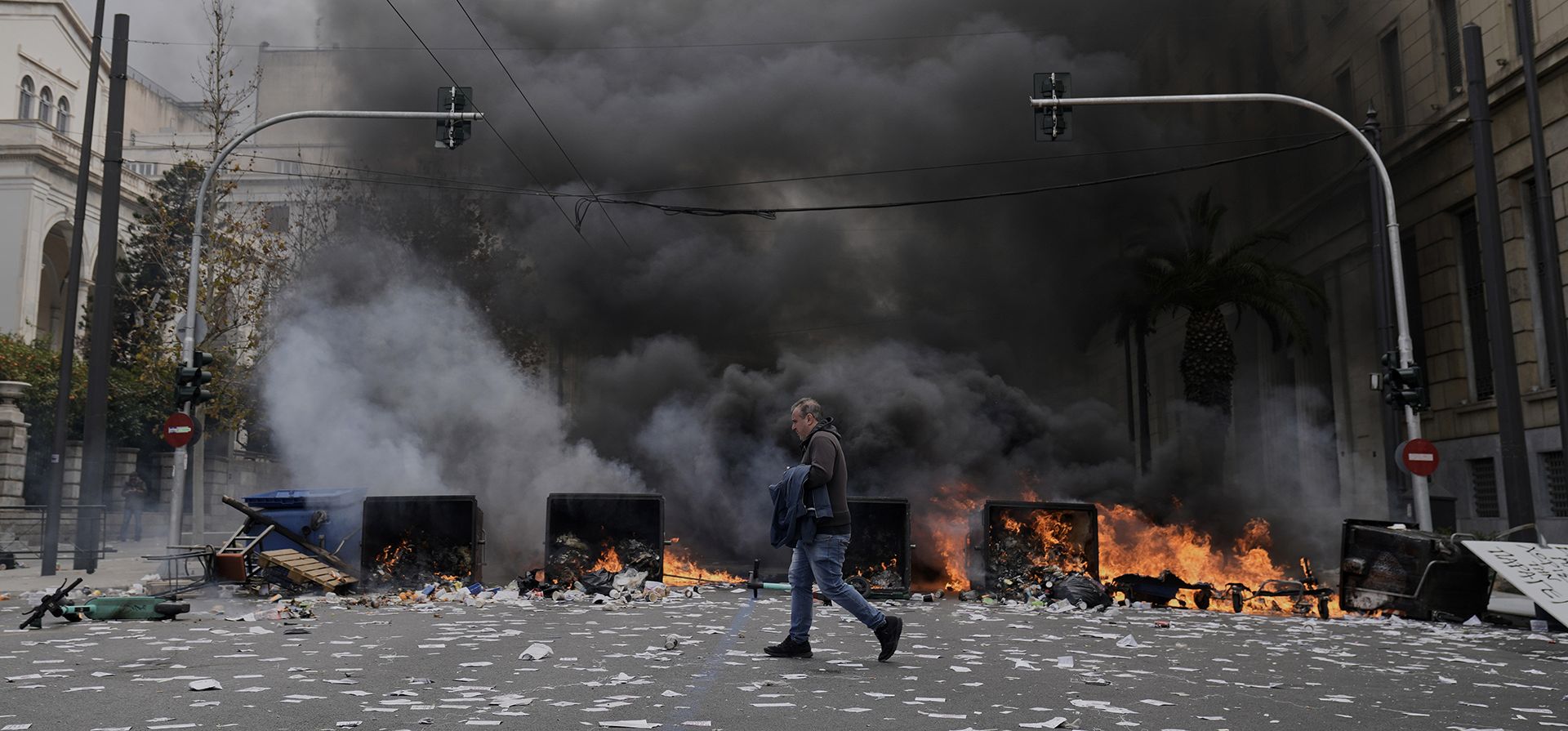 Un manifestante corre mientras la policía antidisturbios se mantiene fuera del Parlamento durante una protesta en el centro de Atenas, Grecia, para conmemorar los dos años del mortal desastre ferroviario que también desencadenó cientos de otras manifestaciones y una huelga general, el viernes 28 de febrero de 2025. (Foto AP/Petros Giannakouris) Un manifestante corre mientras la policía antidisturbios se mantiene fuera del Parlamento durante una protesta en el centro de Atenas, Grecia, para conmemorar los dos años del mortal desastre ferroviario que también desencadenó cientos de otras manifestaciones y una huelga general, el viernes 28 de febrero de 2025. (Foto AP/Petros Giannakouris)