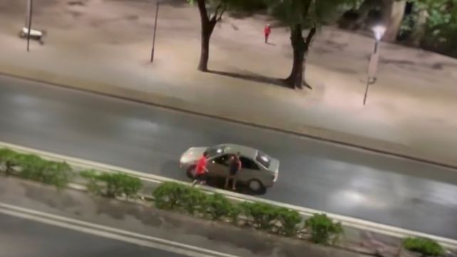 Personas vistiendo la camiseta de Newells atacando automovilistas en las inmediaciones del Parque de la Independencia.