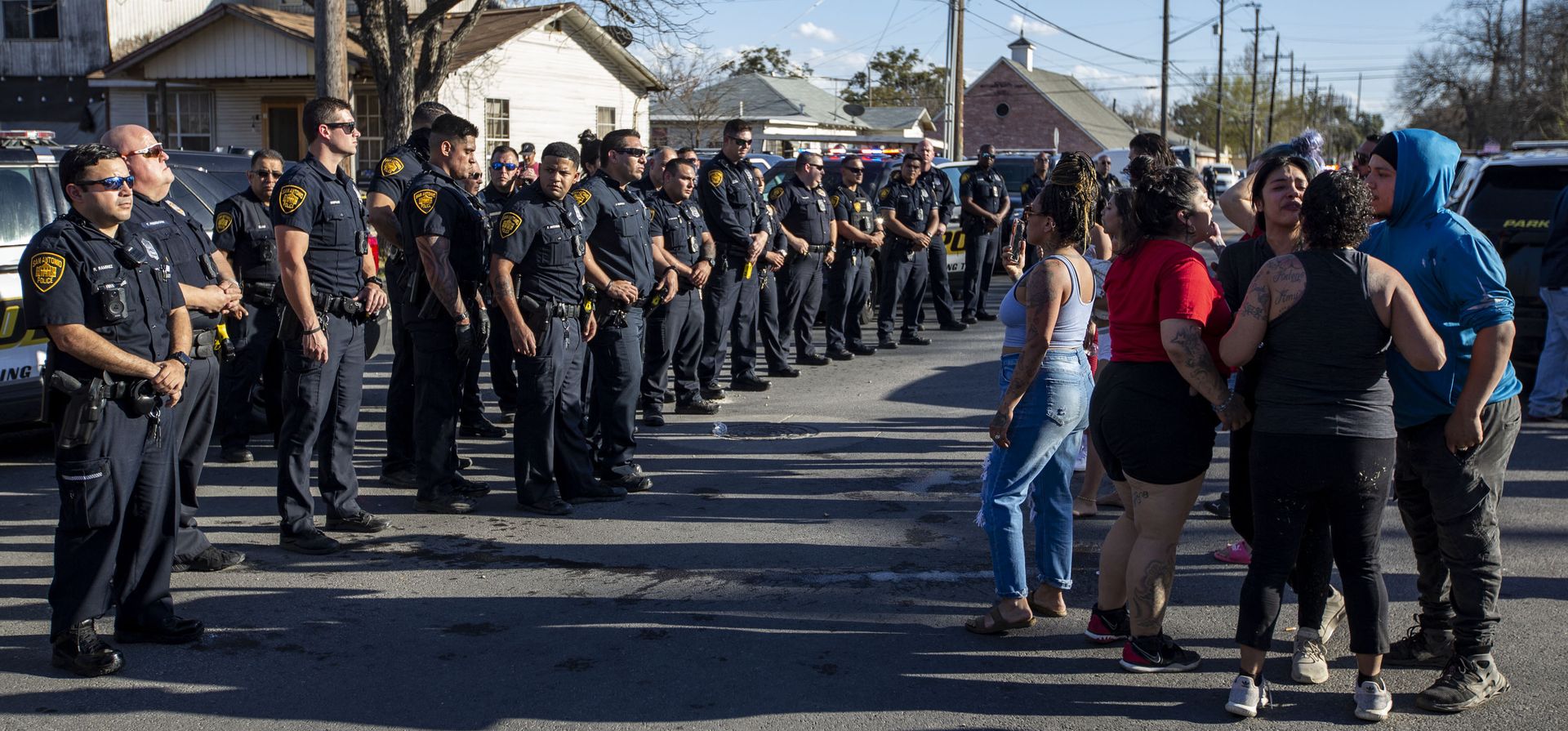 Oficiales del Departamento de Policía de San Antonio vigilan la escena de un tiroteo el lunes 14 de marzo de 2022 en San Antonio, Texas. La policía de San Antonio se enfrentó a una multitud que se reunió después de que tres policías le dispararon fatalmente a un hombre que, según dijeron, sacó un arma mientras intentaban arrestarlo.