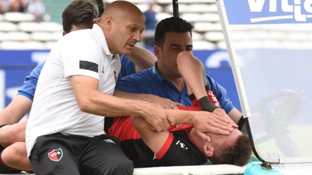 Desconsuelo. Insaurralde es retirado en el carrito junto al kinesiólogo Girotti.