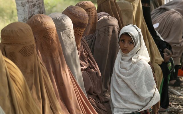 Mujeres pakistaníes esperan recibir vales en efectivo de un oficial bajo el programa de efectivo de emergencia Ehsaas del gobierno para familias necesitadas