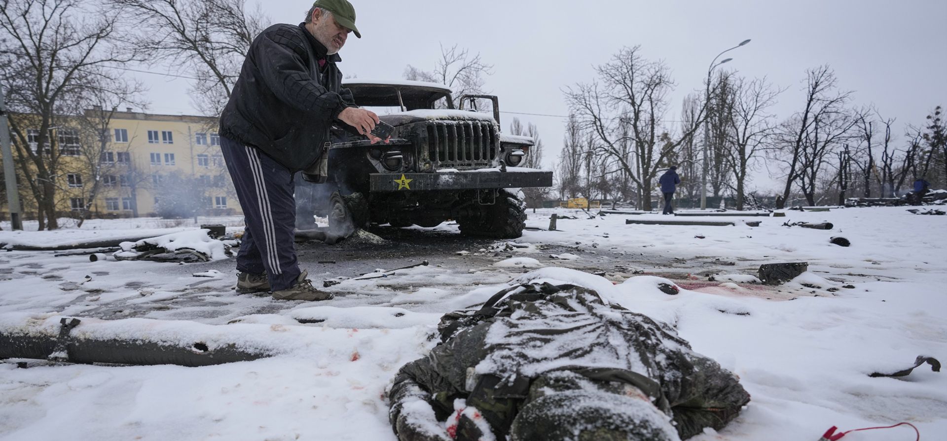 El cuerpo de un militar cubierto de nieve yace junto a un vehículo militar ruso lanzacohetes múltiple destruido, en las afueras de Kharkiv, Ucrania, el viernes 25 de febrero de 2022.