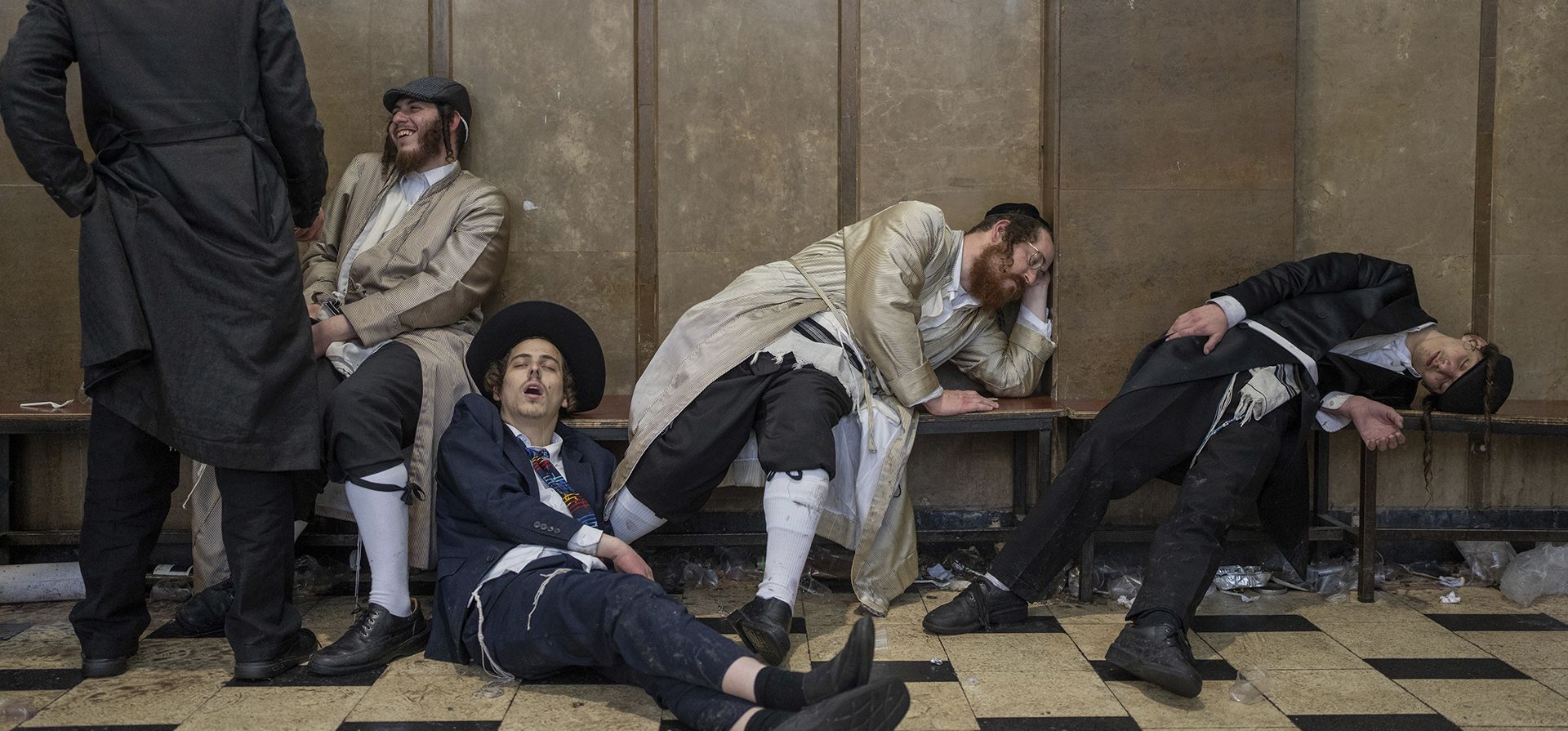 Judíos ultraortodoxos descansan después de emborracharse durante las celebraciones de la festividad judía de Purim en el barrio ultraortodoxo de Mea Shearim en Jerusalén, el miércoles 8 de marzo de 2023. La festividad judía de Purim celebra la salvación de los judíos del genocidio en la antigua Persia. como se relata en el Rollo de Ester. (Foto AP/Ohad Zwigenberg)