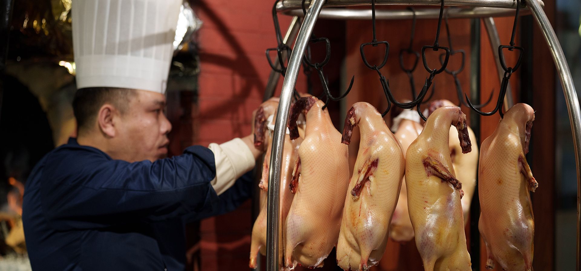 Un chef prepara patos asados colgados en una cocina de Pekín, China, el jueves 12 de febrero de 2026. (Foto AP/Vincent Thian) Un chef prepara patos asados colgados en una cocina de Pekín, China, el jueves 12 de febrero de 2026. (Foto AP/Vincent Thian)