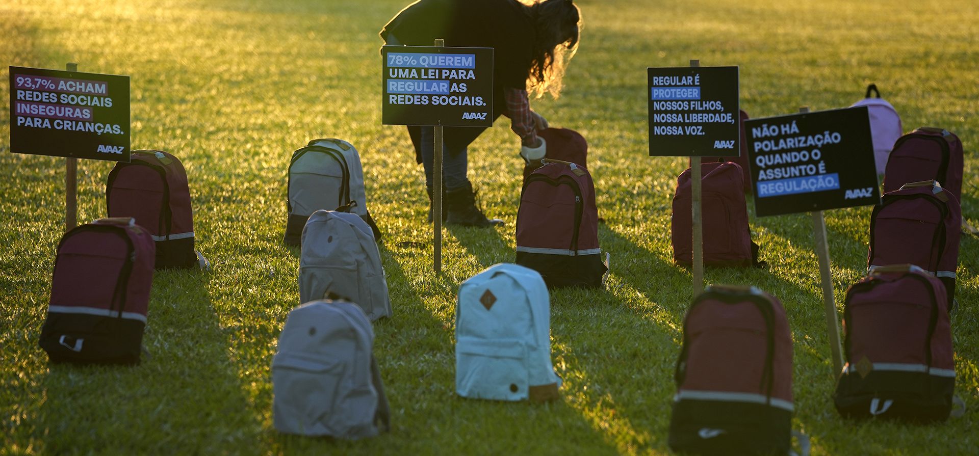 Un activista de Avaaz coloca mochilas escolares que representan a las víctimas de las masacres escolares como parte de una protesta a favor de la aprobación de un proyecto de ley, llamado Fake News Project, que tiene como objetivo regular las redes sociales, frente al Congreso Nacional en Brasilia, Brasil, el martes 2 de mayo. (Foto AP/Eraldo Peres)