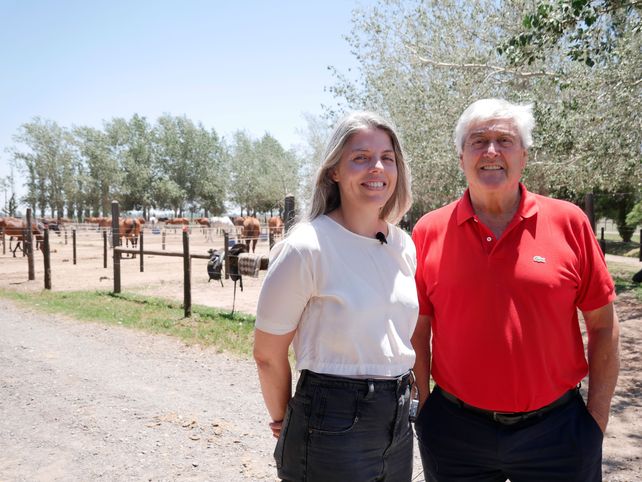 Julia y Dado Carey frente a los corrales de caballos de polo y salto.