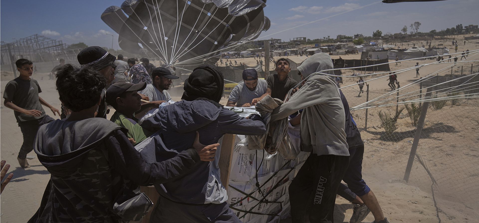 Palestinos se apresuran a recoger ayuda humanitaria lanzada en paracaídas sobre Deir al-Balah, en el centro de la Franja de Gaza. (Foto AP/Abdel Kareem Hana) Palestinos se apresuran a recoger ayuda humanitaria lanzada en paracaídas sobre Deir al-Balah, en el centro de la Franja de Gaza. (Foto AP/Abdel Kareem Hana)