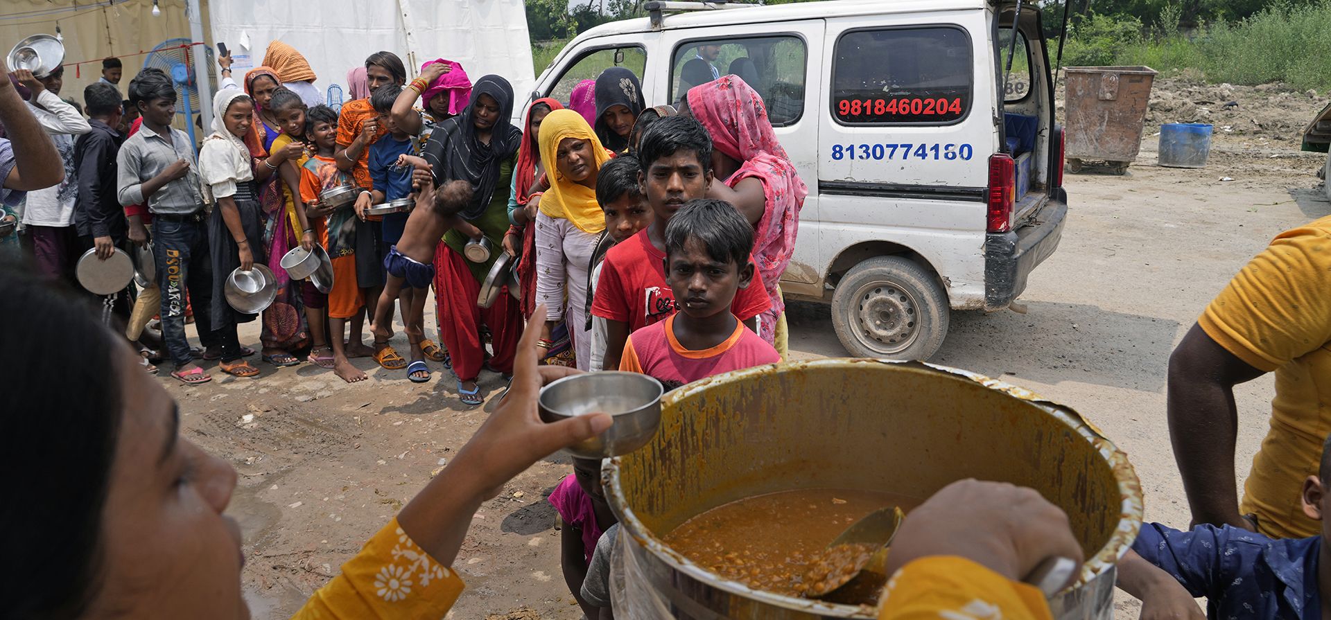 Mujeres y niños desplazados debido a la inundación del río Yamuna esperan en una fila para recibir alimentos gratis en Nueva Delhi, India, el jueves 27 de julio de 2023. Las lluvias monzónicas récord de la semana pasada provocaron la inundación del río Yamuna. (Foto AP/Manish Swarup) Mujeres y niños desplazados debido a la inundación del río Yamuna esperan en una fila para recibir alimentos gratis en Nueva Delhi, India, el jueves 27 de julio de 2023. Las lluvias monzónicas récord de la semana pasada provocaron la inundación del río Yamuna. (Foto AP/Manish Swarup)