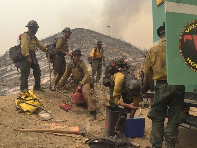 Sin tregua. Un grupo de bomberos se reponen del intenso trabajo. &nbsp;