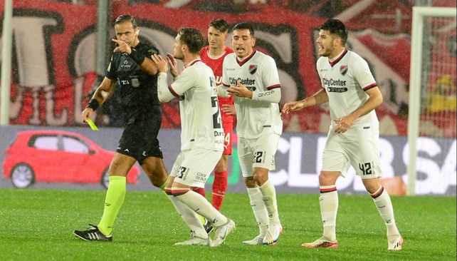 Los jugadores de Newells persiguen a Ariel Penel tras anular el gol por falta de Martino.