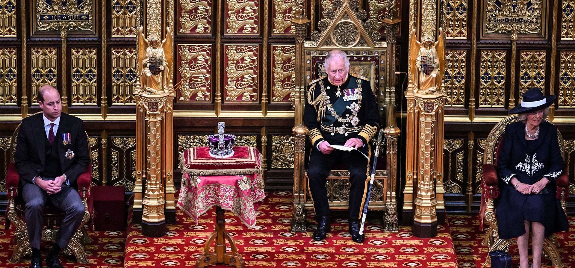 El Príncipe Carlos de Gran Bretaña, en el centro, lee el Discurso de la Reina mientras se sienta junto a la Corona del Estado Imperial con Camilla, Duquesa de Cornualles, a la derecha, y el Príncipe Guillermo de Gran Bretaña durante la Apertura Estatal del Parlamento, en las Casas del Parlamento, en Londres, el martes. 10 de mayo de 2022.
