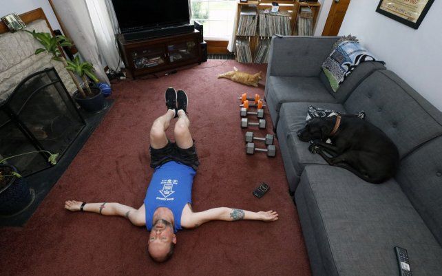 Christian Hainds se estira después de su sesión de entrenamiento en su casa en Hammond, Indiana. Los funcionarios de salud advirtieron desde el comienzo de la pandemia que la obesidad y condiciones relacionadas a la diabetes eran factores de riesgo de COVID-19 grave.