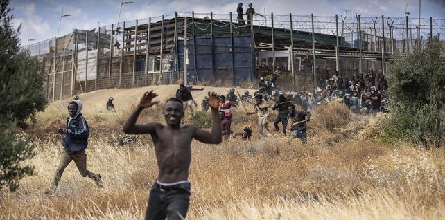Migrantes corren por suelo español después de cruzar las vallas que separan el enclave español de Melilla de Marruecos en Melilla. Decenas de migrantes irrumpieron el viernes en el cruce fronterizo entre Marruecos y el enclave español de Melilla en lo que es la primera incursión de este tipo desde que España y Marruecos repararon relaciones diplomáticas el mes pasado.