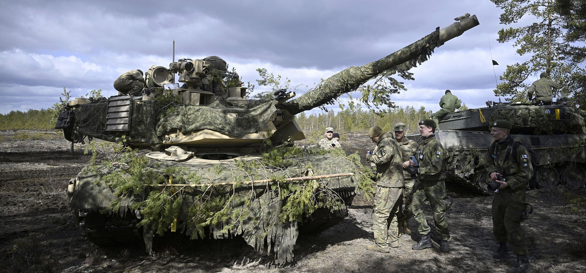 Soldados finlandeses se paran junto a tanques M1 Abrams durante el ejercicio mecanizado Arrow 23| del ejército finlandés en el área de entrenamiento y tiro de Pohjankangas en Niinisalo, Finlandia, el jueves 4 de mayo de 2023. Unidades de las fuerzas terrestres del Reino Unido, Letonia, Lituania, Estonia y Estados Unidos participará en el ejercicio. (Antti Aimo-Koivisto/Lehtikuva vía AP)