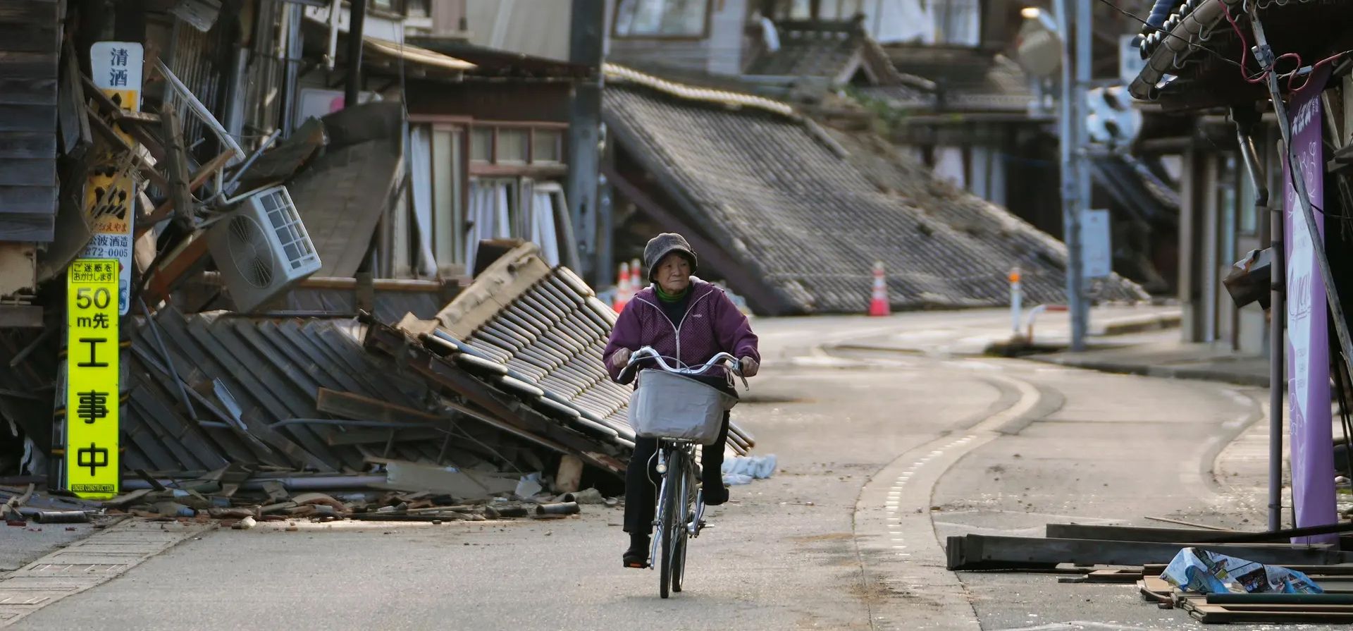Una mujer pedalea por una calle desierta tras la destrucción causada por el terremoto del lunes, Noto, Japón. Fotografía: Hiro Komae/AP Una mujer pedalea por una calle desierta tras la destrucción causada por el terremoto del lunes, Noto, Japón. Fotografía: Hiro Komae/AP