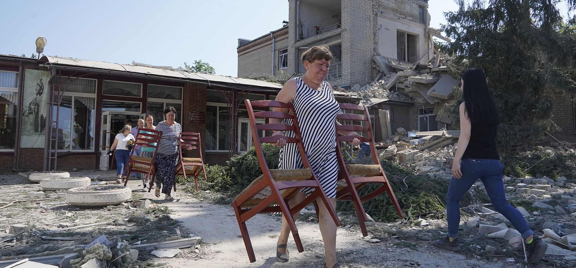 Maestros sacan sillas de una escuela destruida durante un ataque con misiles en Kharkiv, Ucrania, el lunes 4 de julio de 2022.