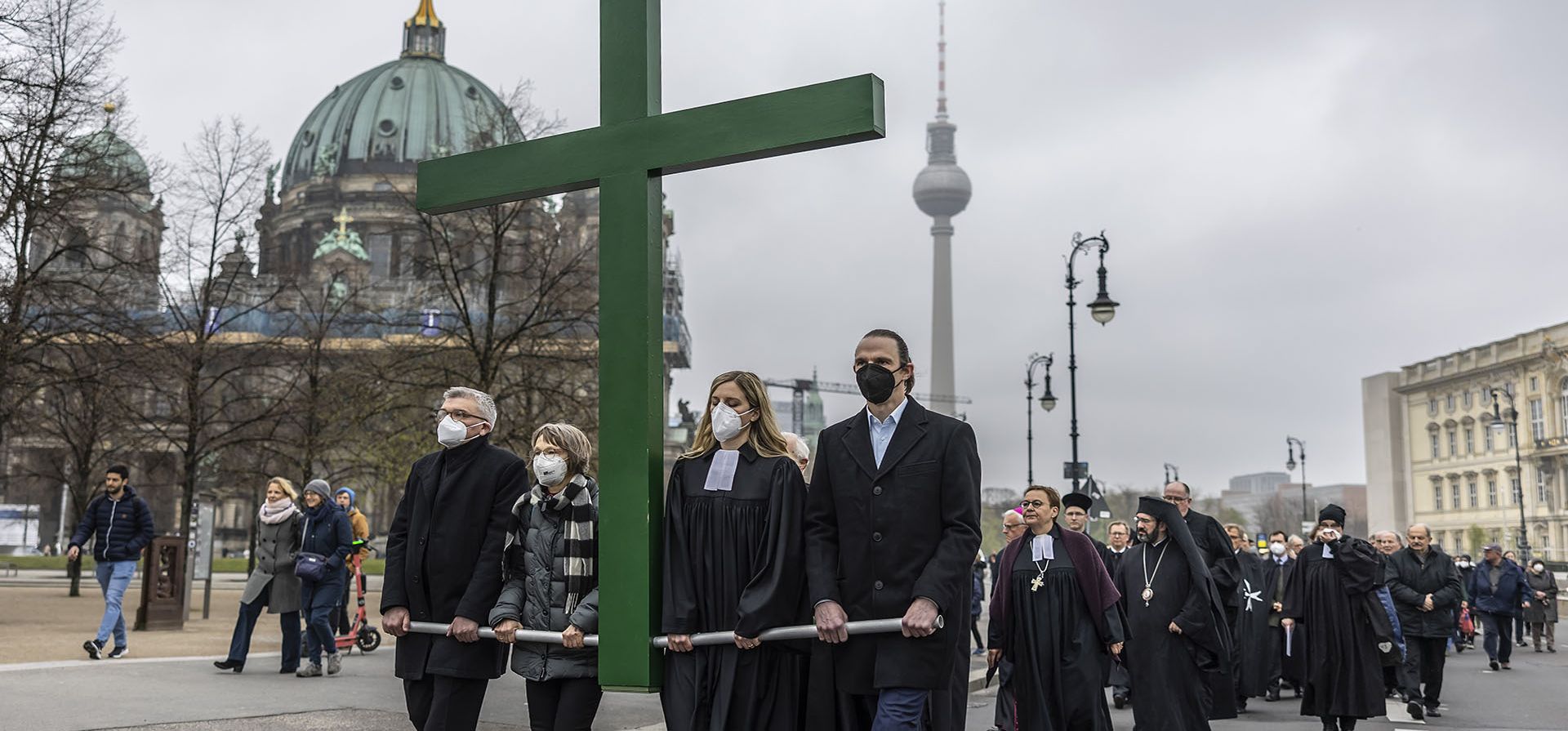 Decenas de personas participan en la procesión del Viernes Santo frente a la Catedral de Berlín y la torre de televisión en Berlín, Alemania, el viernes 15 de abril de 2022.