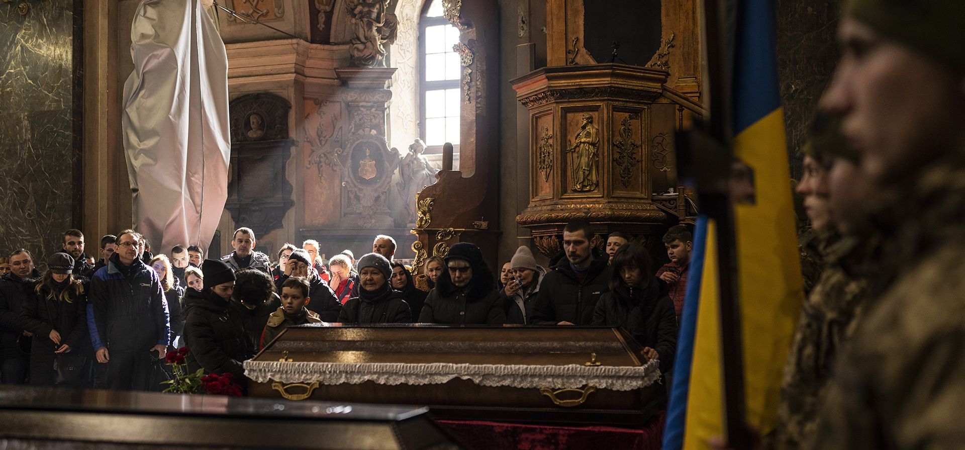 Familiares y amigos asisten a una ceremonia fúnebre de los soldados Vladyslav Tkachenko, de 45 años, y Vladyslav Belechynskyi, de 20, dentro de la Iglesia de los Santos Apóstoles Pedro y Pablo en Lviv, en el oeste de Ucrania, el miércoles 22 de febrero de 2023. ( Foto AP/Petros Giannakouris)