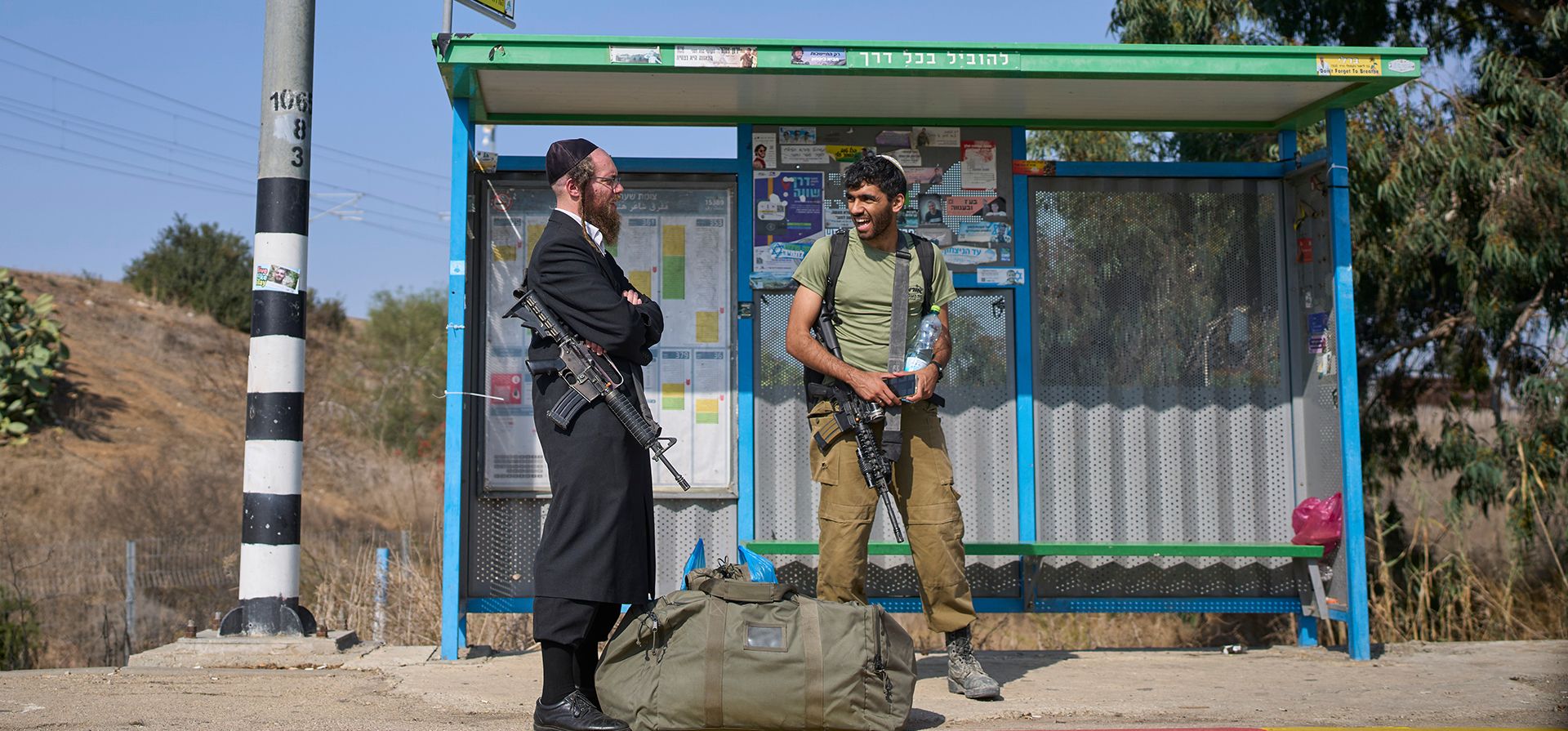 Un soldado israelí y un hombre judío ultraortodoxo armado se encuentran en una parada de autobús cerca de la frontera con Gaza, en el sur de Israel, el martes 18 de noviembre de 2025. (Foto AP/Ohad Zwigenberg) Un soldado israelí y un hombre judío ultraortodoxo armado se encuentran en una parada de autobús cerca de la frontera con Gaza, en el sur de Israel, el martes 18 de noviembre de 2025. (Foto AP/Ohad Zwigenberg)