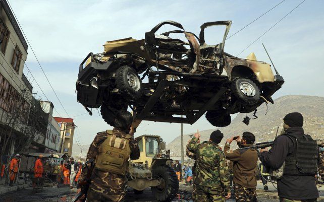 Personal de seguridad afgano retira un vehículo dañado después de un ataque con bomba en Kabul, Afganistán. Una bomba adherida a un vehículo del ejército explotó, matando e hiriendo a varias personas.