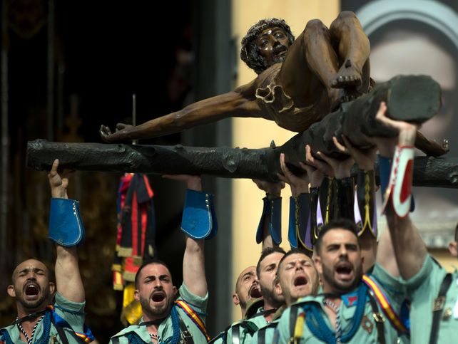 Legionarios alzan el Cristo de la Buena Muerte en Málaga.